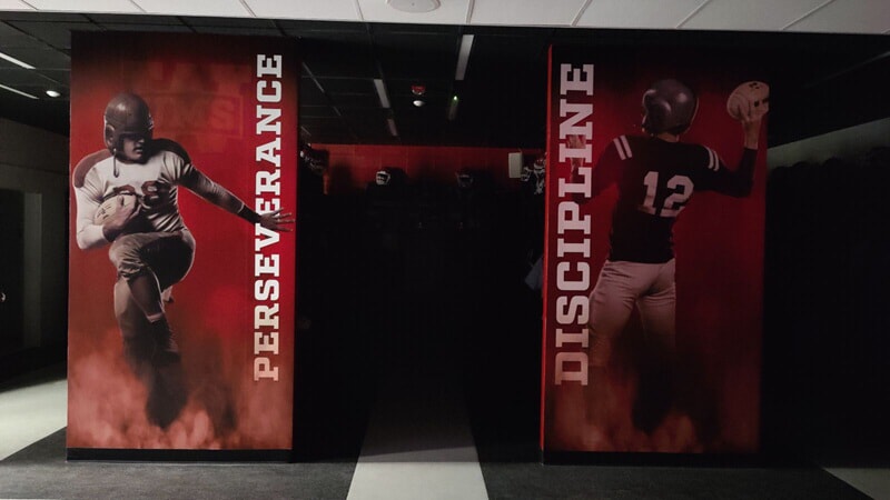 An image of the interior signage inside the locker room showing men throwing footballs.